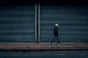 man in black jacket walking on sidewalk during daytime